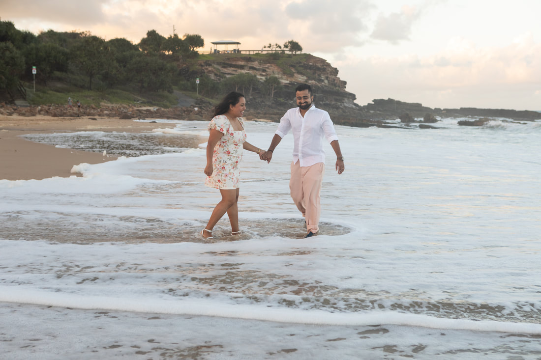 couple walking on a beach Sunshine Coast QLD