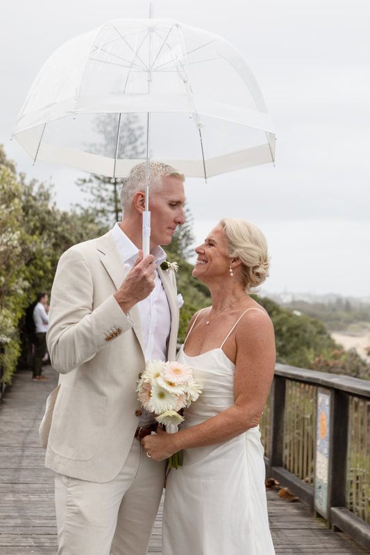 bridge and groom under an umbrella